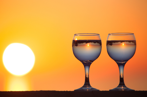 image of sun reflected in two glasses of water